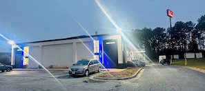 A building with a parking lot, a car, and a sign with a red symbol. - Econo Lodge Union City - Atlanta South (Union City)