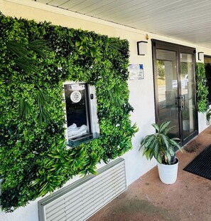 A building with a green wall, a window with a sign, and a door. - Econo Lodge Union City - Atlanta South (Union City)