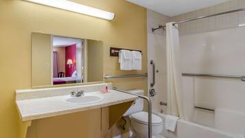 A bathroom with a sink, mirror, toilet, and bathtub.