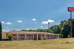 A motel with multiple rooms, a parking lot, and a clear sky. - Econo Lodge Union City - Atlanta South (Union City)