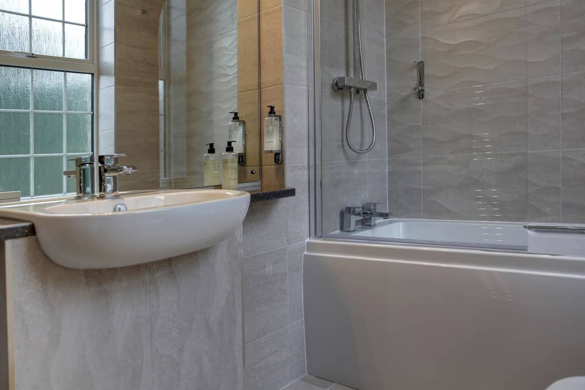 Une salle de bain moderne avec un grand lavabo, une baignoire et une douche à parois de verre.