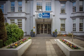 Entrada de hotel com uma placa indicando "Best Western New Kent Hotel".