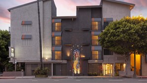 A modern building with a unique mural, multiple balconies, and a well-lit entrance. - The Inn at Venice Beach (Venice)