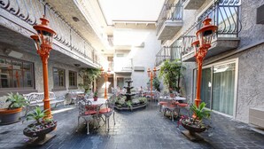 A courtyard with outdoor seating, a central fountain, and potted plants. - The Inn at Venice Beach (Venice)