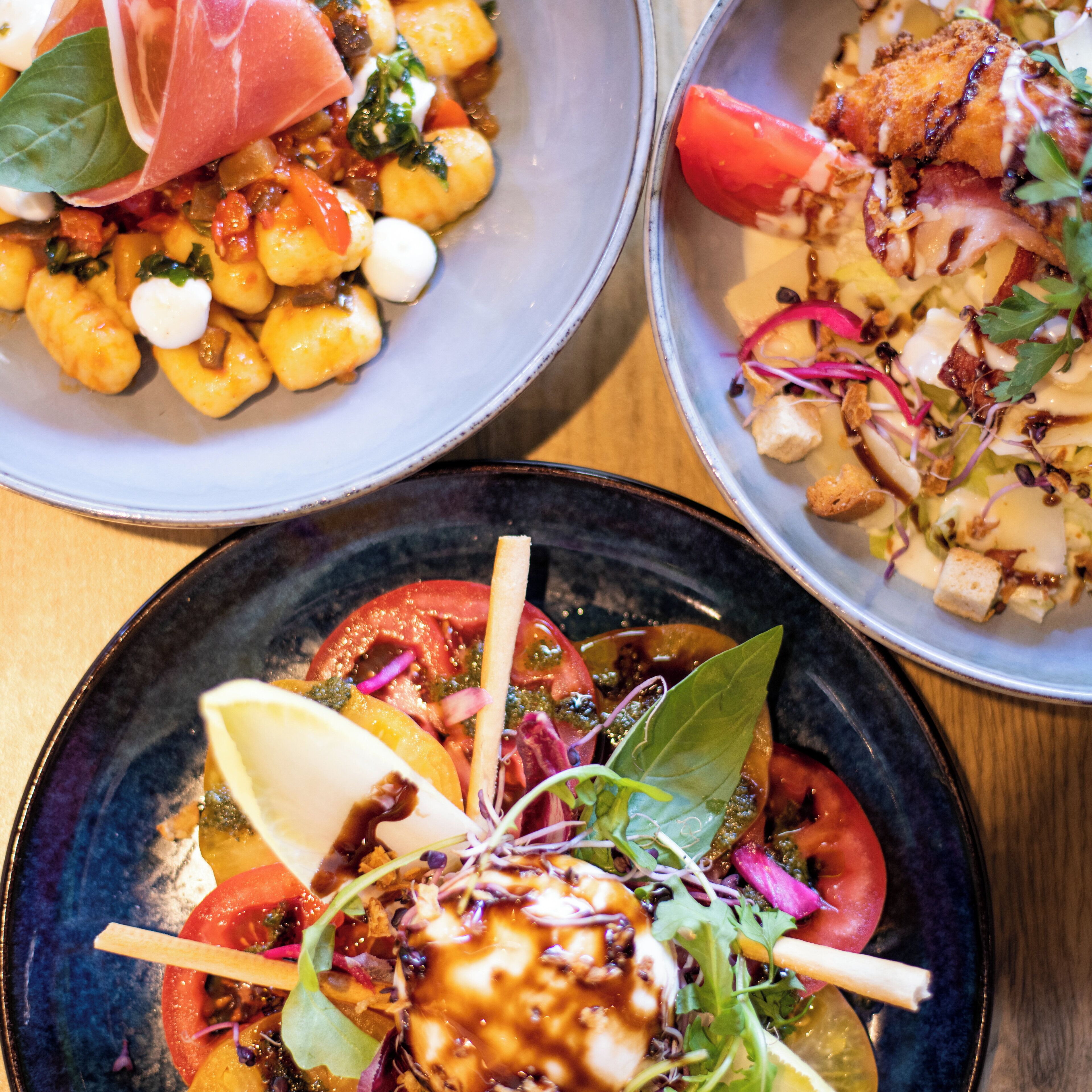 Three bowls of food with various ingredients and garnishes.