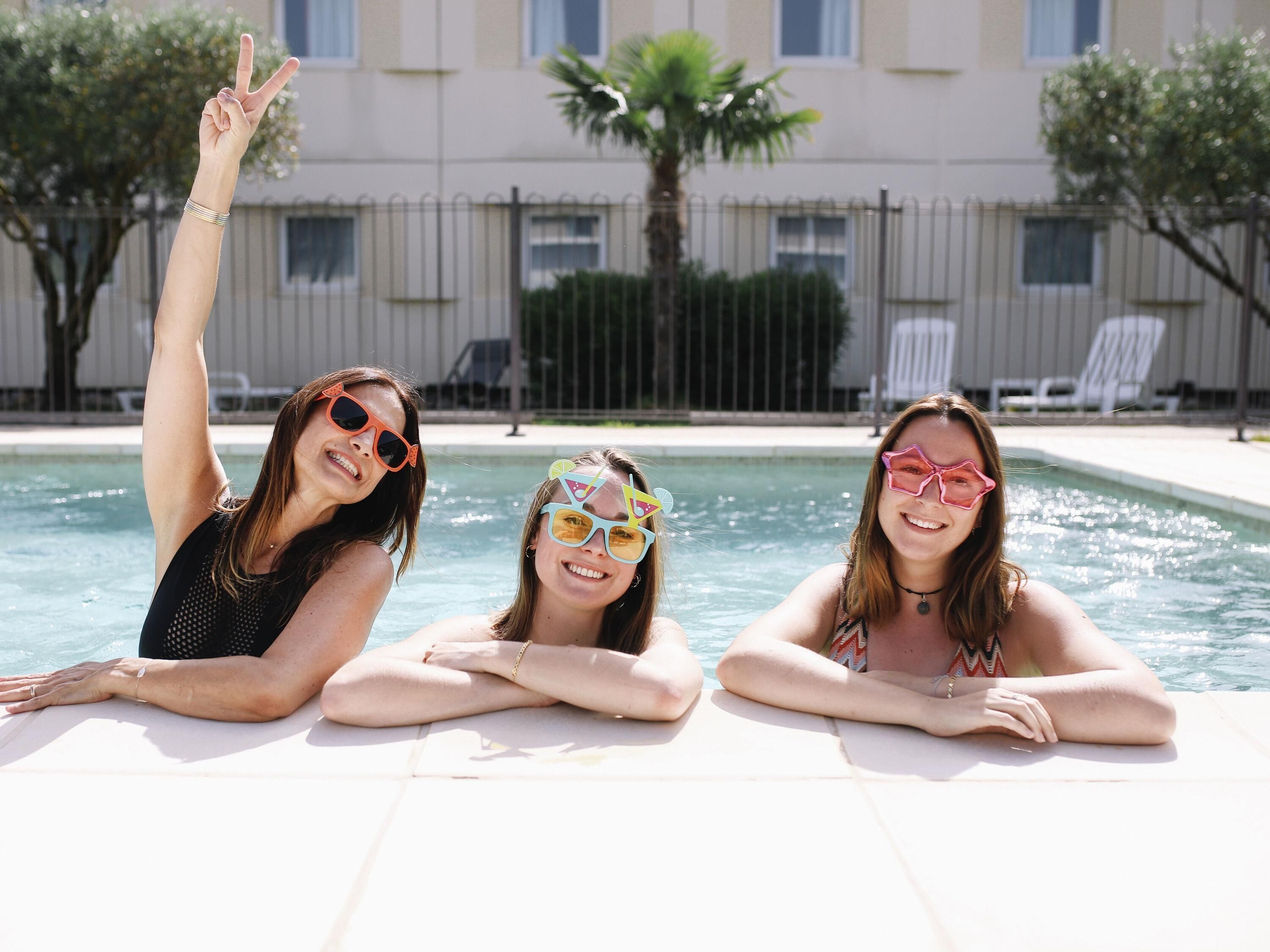 Una piscina al aire libre, sillones reclinables de piscina