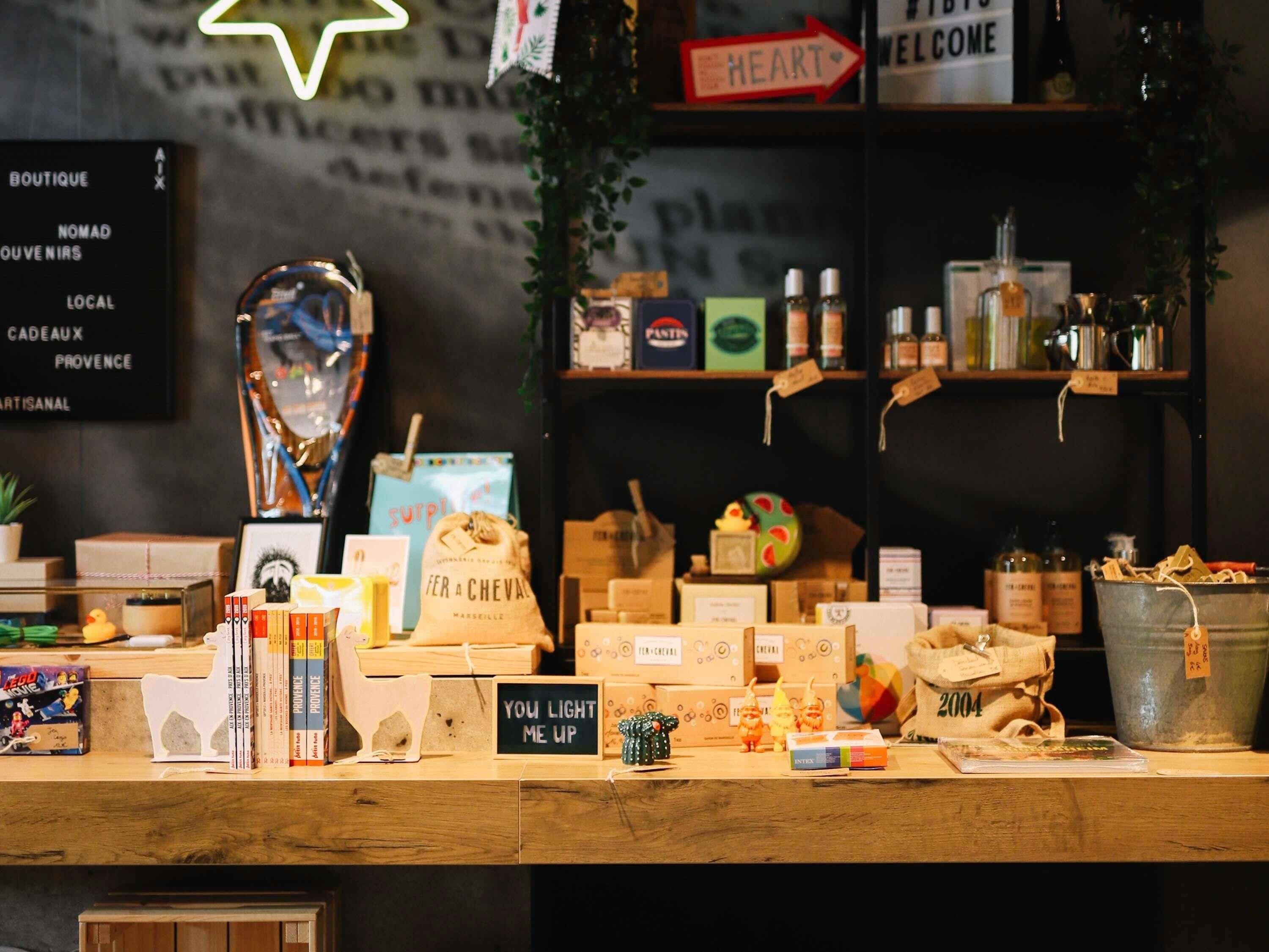 Un comptoir de vente proposant divers articles, notamment des livres, une enseigne sur laquelle on peut lire « You Light Me Up » et une autre en forme de cœur.