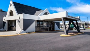 A modern building with a unique architectural design, featuring a covered entrance area and a parking lot. - Quality Inn & Suites Council Bluffs - Omaha East (Council Bluffs)