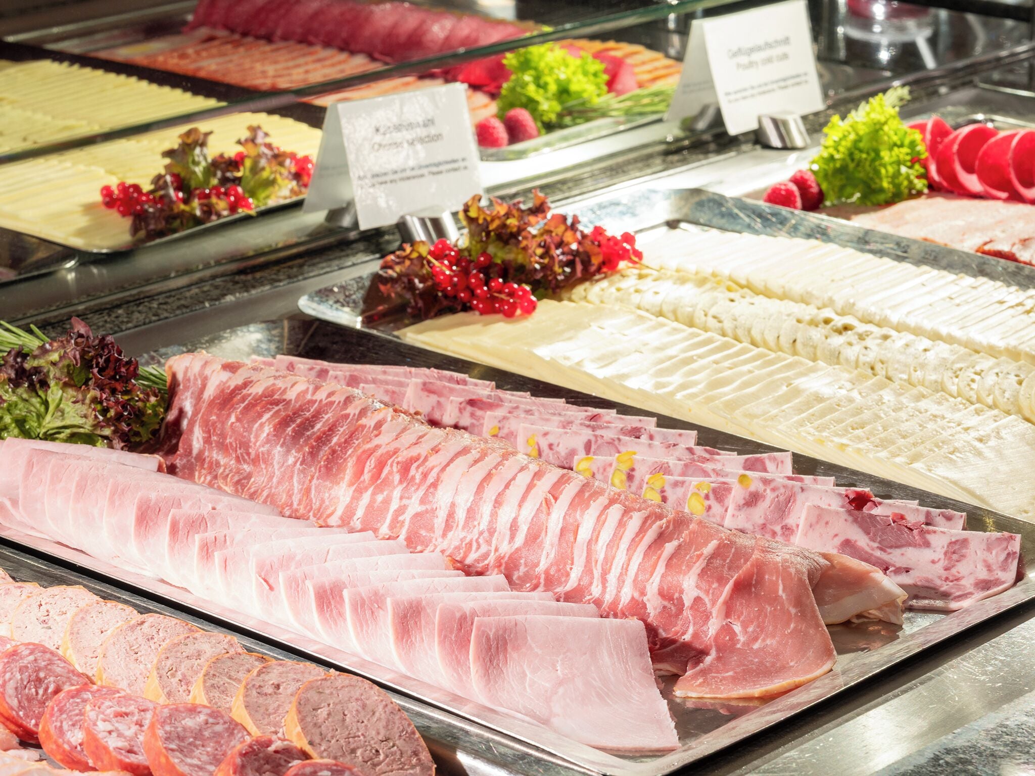 Mostrador de charcutería con diferentes carnes y quesos.