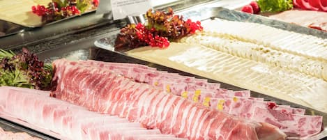Mostrador de charcutería con diferentes carnes y quesos.