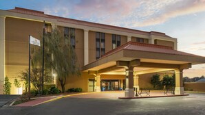 A hotel with a covered entrance, a flag, and a parking area. - La Quinta Inn & Suites by Wyndham Memphis Airport Graceland (Memphis)