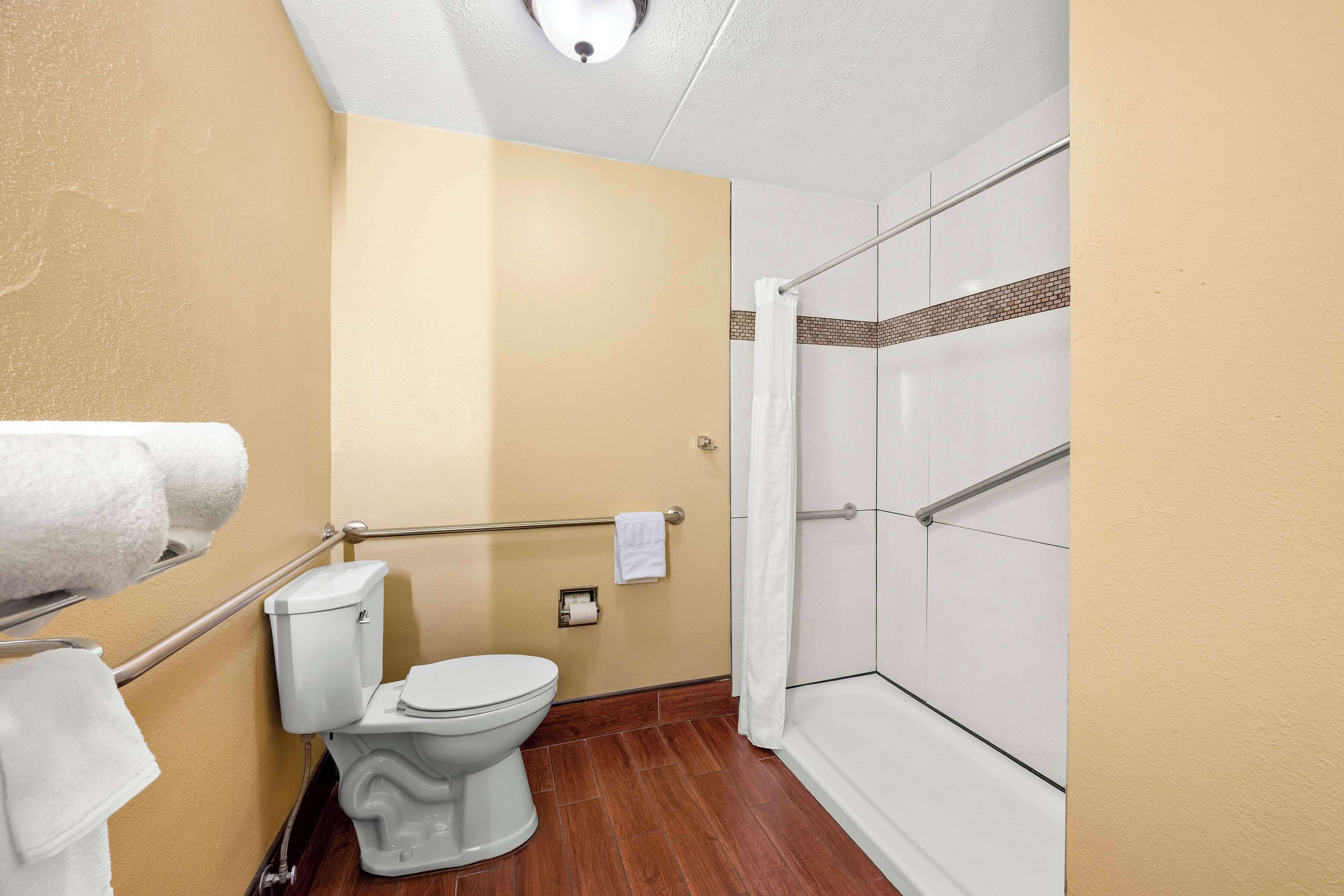 A bathroom with a toilet, a shower with a glass door, and a towel rack.