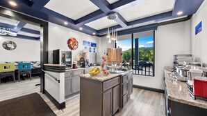 Een moderne keuken met een groot eiland, inbouwapparatuur en uitzicht op de omgeving.