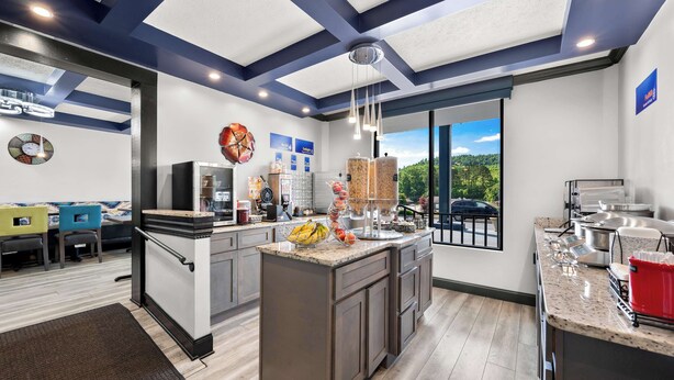 A modern kitchen with a large island, built-in appliances, and a view of the outdoors.