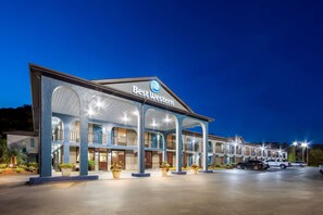 A Best Western hotel with a covered outdoor area, multiple balconies, and a parking lot with vehicles.