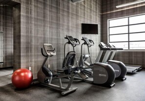 Una palestra con attrezzature per esercizi, una palla rossa da ginnastica e un'ampia finestra.