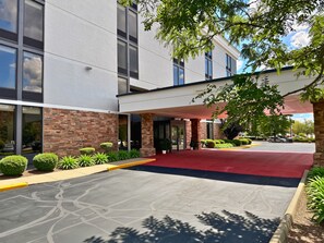 A modern building with a red carpet entrance, stone facade, and a covered walkway. - enVision Hotel Worcester Downtown (Worcester)