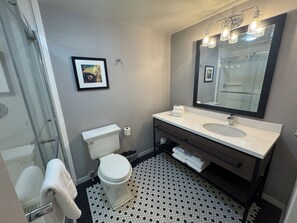 A bathroom with a toilet, sink, and shower. - enVision Hotel Worcester Downtown (Worcester)