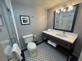 Un baño con inodoro, lavamanos y ducha.