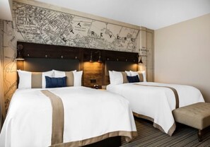 A hotel room with two beds, a map on the wall, and a wooden headboard. - enVision Hotel Worcester Downtown (Worcester)