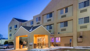 Un hôtel à plusieurs étages doté d’une entrée principale, d’un parking et d’un terrain enneigé.