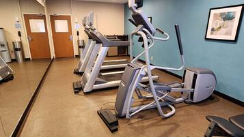 A fitness center with treadmills, elliptical machines, and a stationary bike.