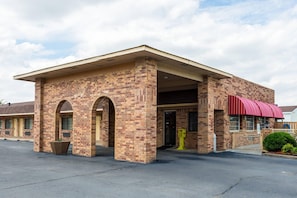 A brick building with a flat roof, two arched doorways, and a covered entrance.