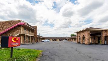 A motel with a brick facade, a covered parking area, and a sign for EconoLodge Inn & Suites.