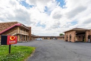 Un motel con fachada de ladrillo, zona de estacionamiento techada y letrero de EconoLodge Inn & Suites.