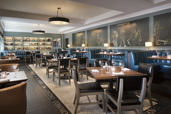 A restaurant with booths, tables, and a bar area.