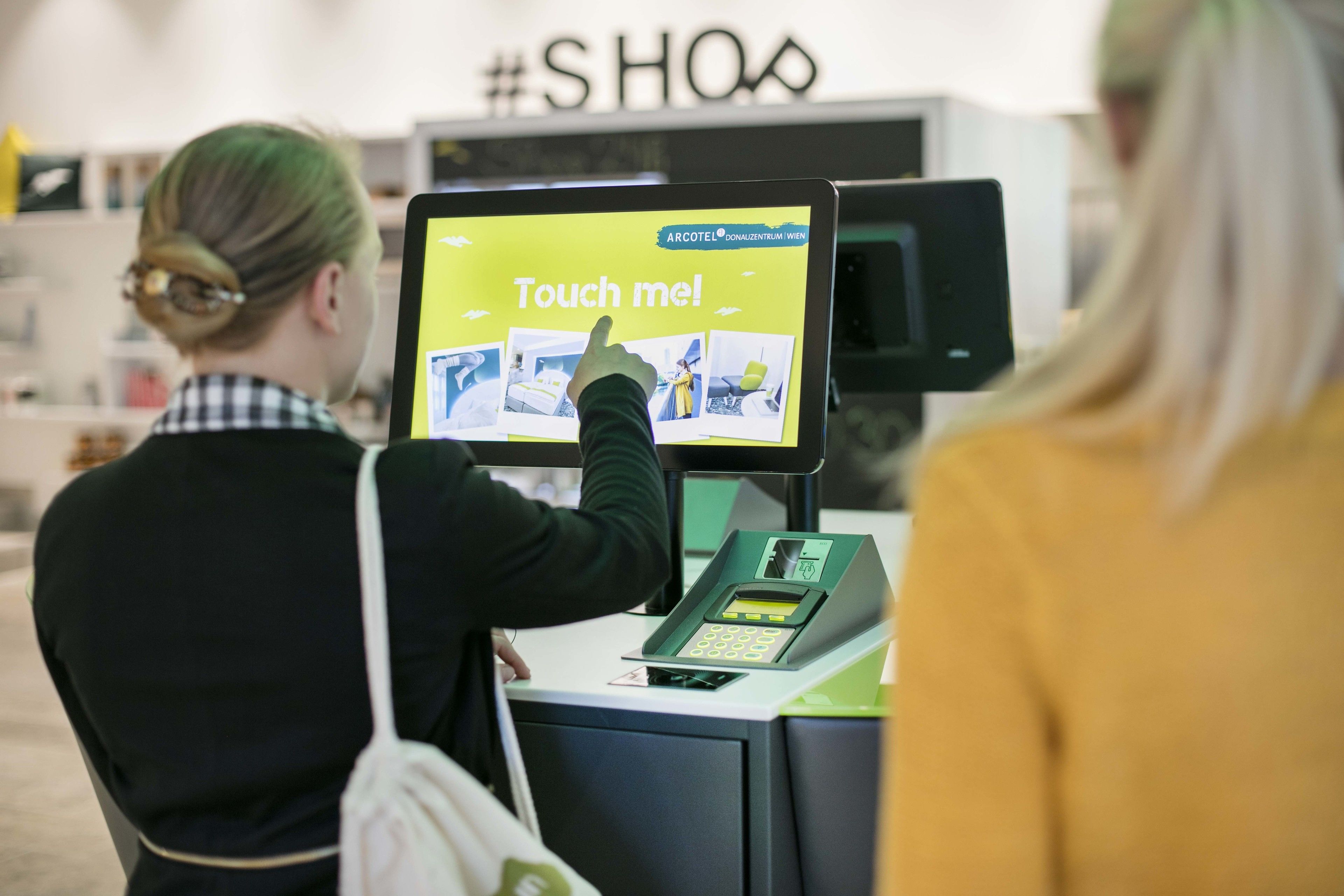 Une personne utilisant un écran tactile interactif situé dans le hall d’un hôtel.