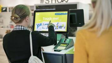 Une personne utilisant un écran tactile interactif situé dans le hall d’un hôtel.