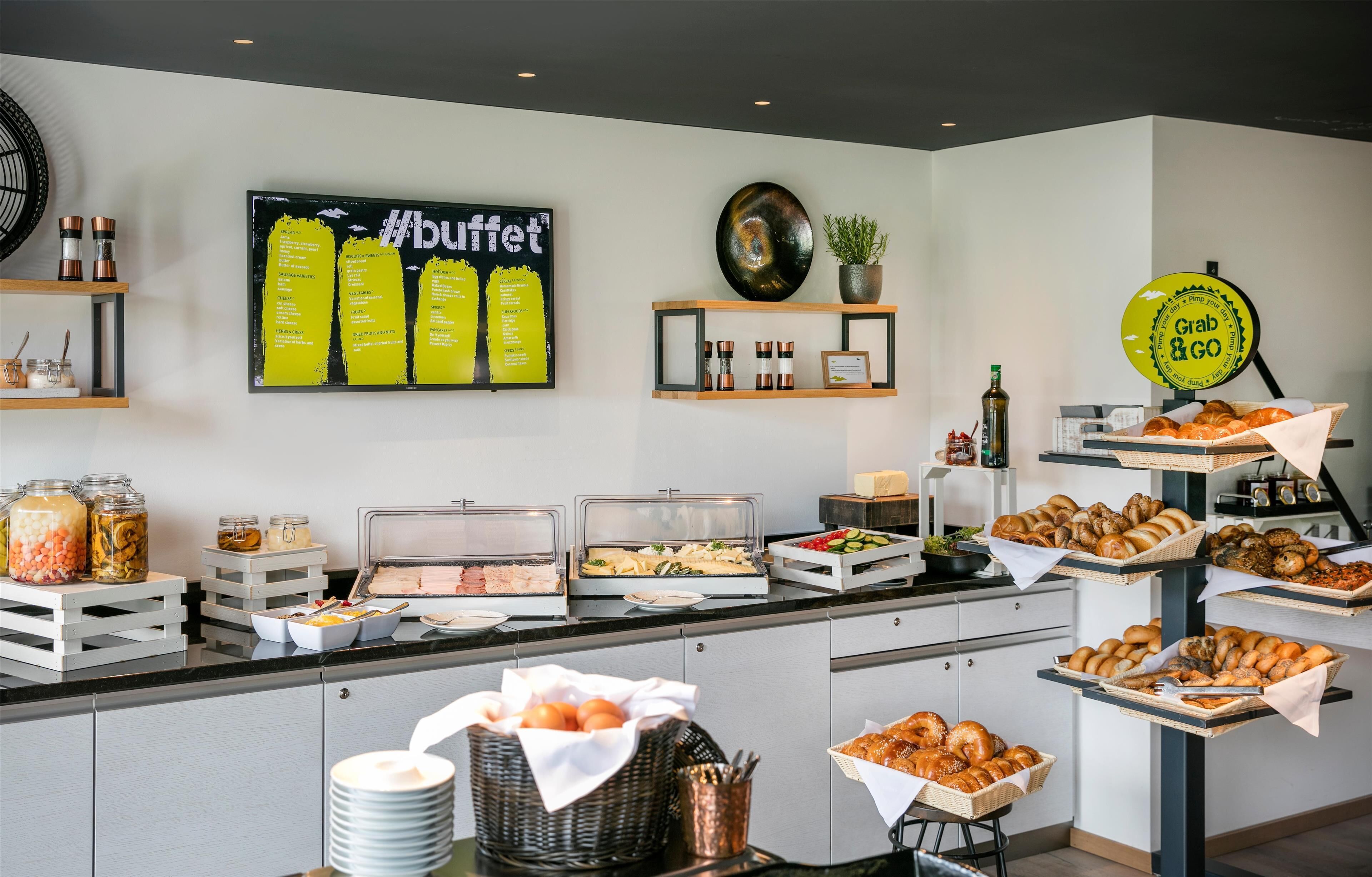 A buffet setup with various food items and a sign that says "Grab & Go".