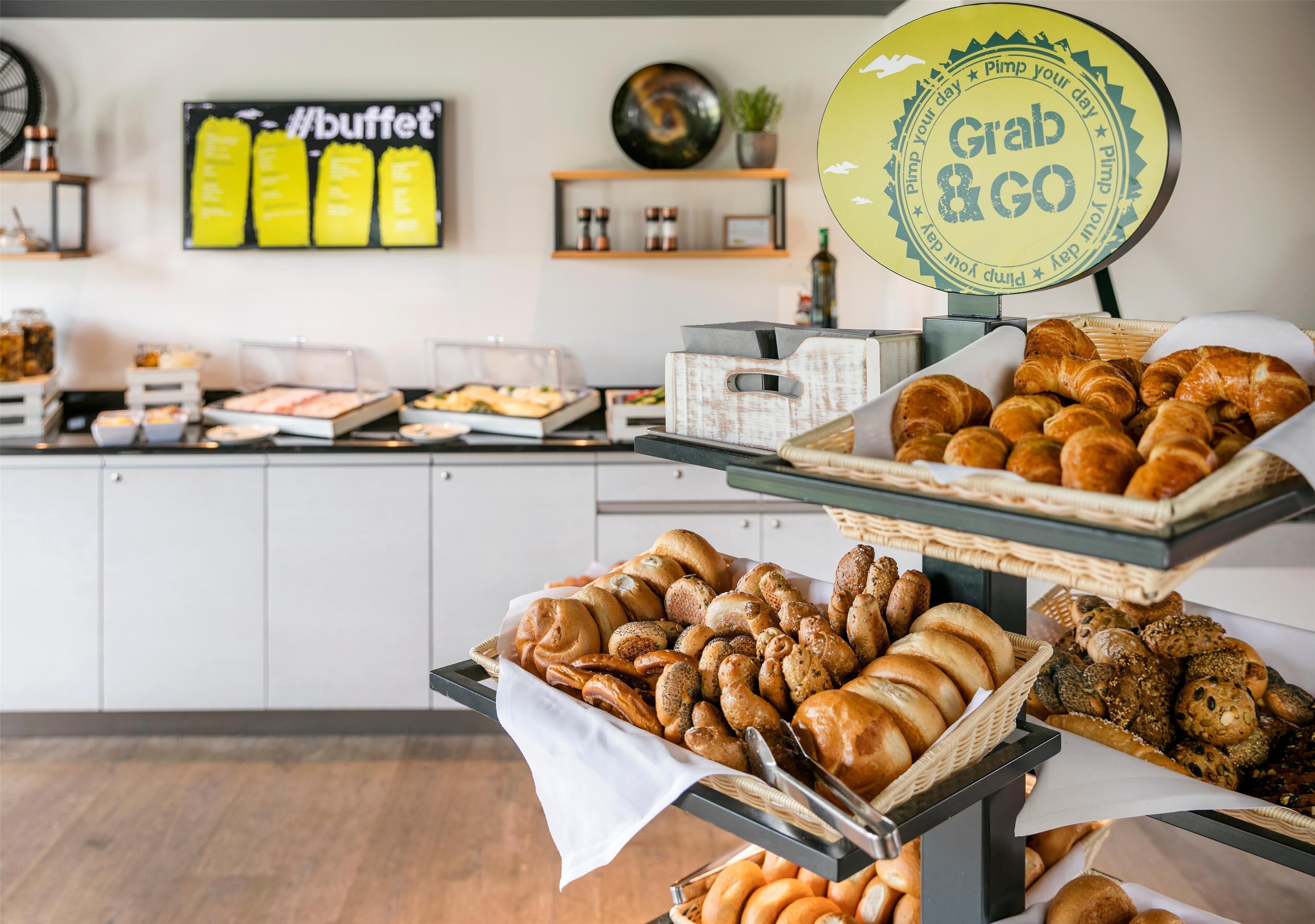 A buffet area with various baked goods displayed on trays and baskets.