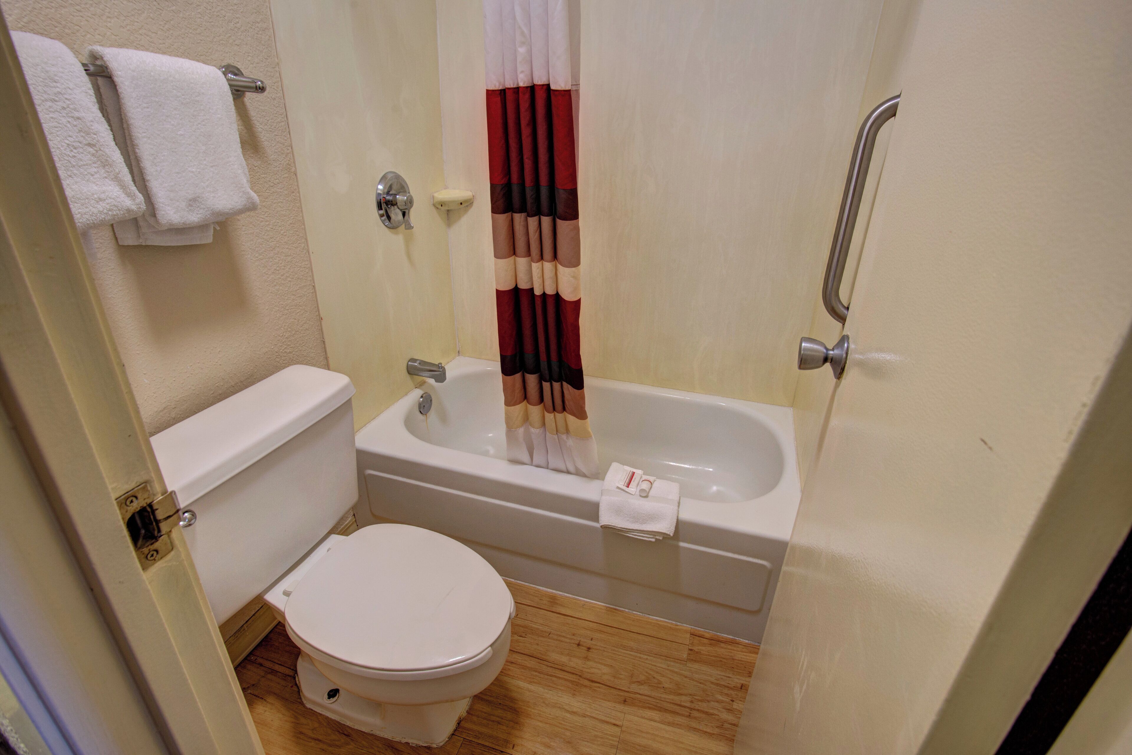 A small bathroom with a toilet, a bathtub, and a shower curtain.