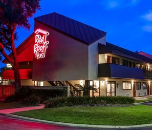 Un edificio con un llamativo letrero de neón que dice 'Red Roof Inn'.