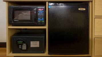 Una cocina equipada con microondas, refrigerador y una caja fuerte.