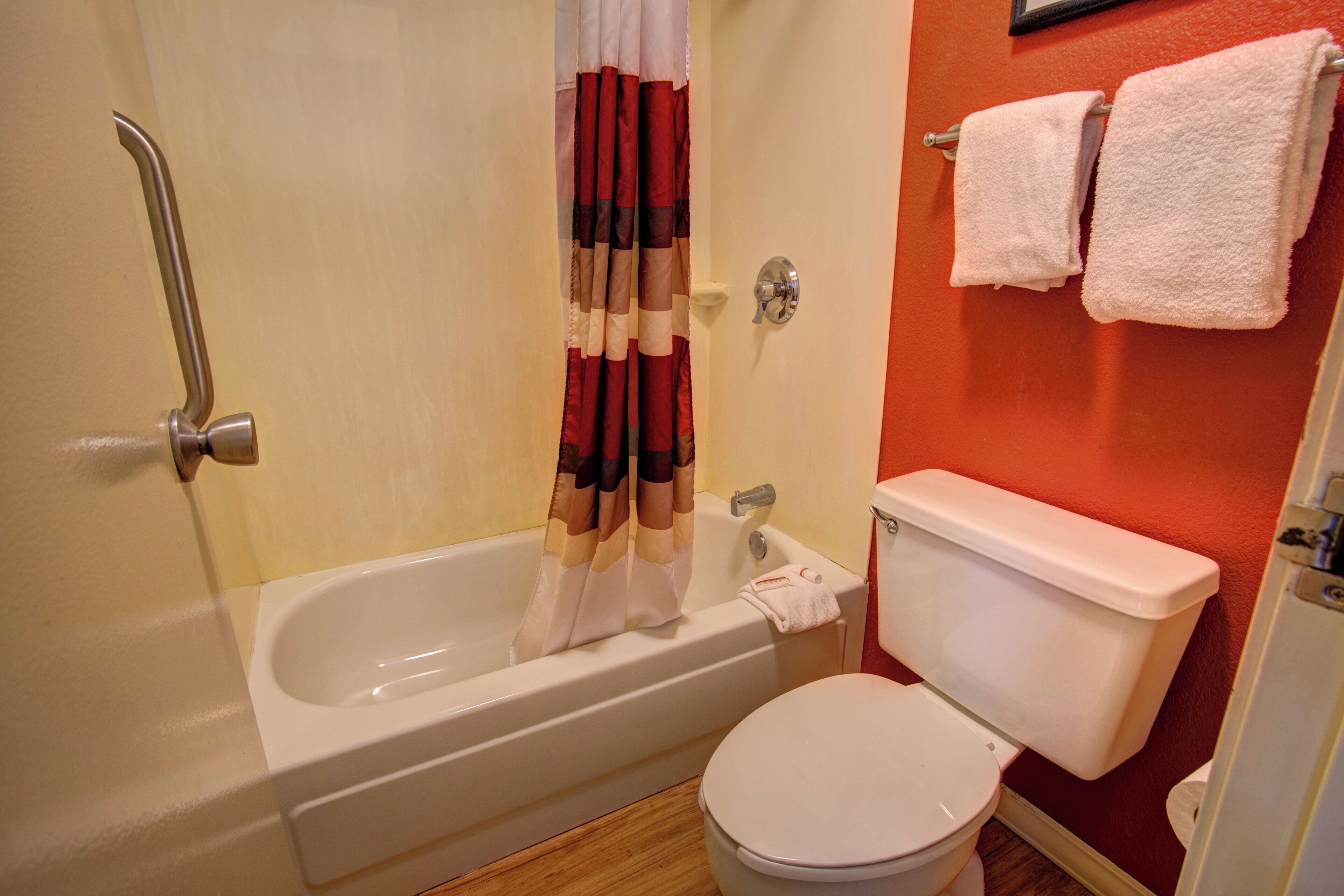 Un baño con bañera, inodoro y cortina de ducha.