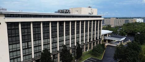 A multi-story building with a parking lot and a covered area.