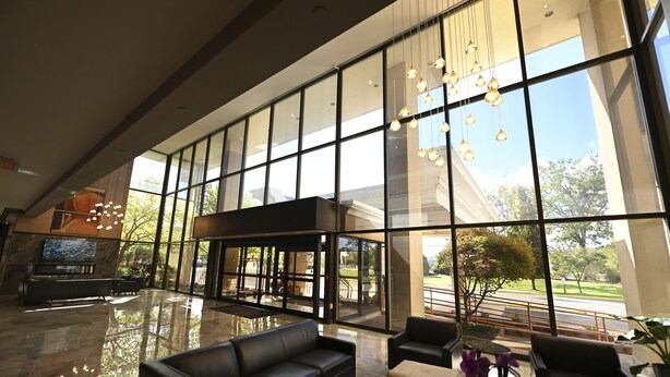Un vestíbulo amplio con una zona de estar generosa, un mostrador de recepción y grandes ventanales que ofrecen vistas al exterior.