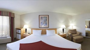 A hotel room with a large bed, two bedside tables with lamps, a chair, a small table, and a framed picture on the wall. - Holiday Inn Express Grants Pass by IHG (Grants Pass)