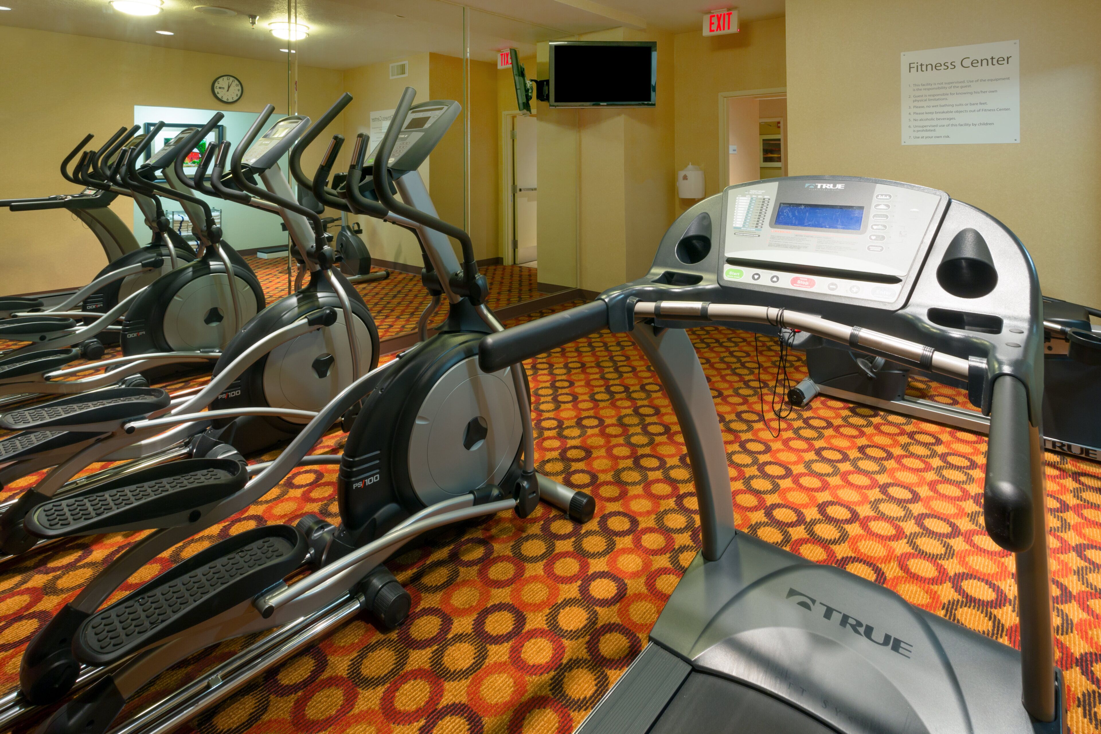Un centre de remise en forme équipé de plusieurs tapis de course et d’appareils d’exercice.
