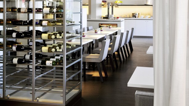 Un comedor moderno con bodega de vinos, mesas y sillas.
