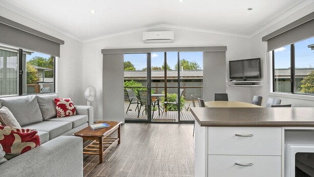 A self-contained cabin with a sofa, coffee table, dining table, and kitchen area.