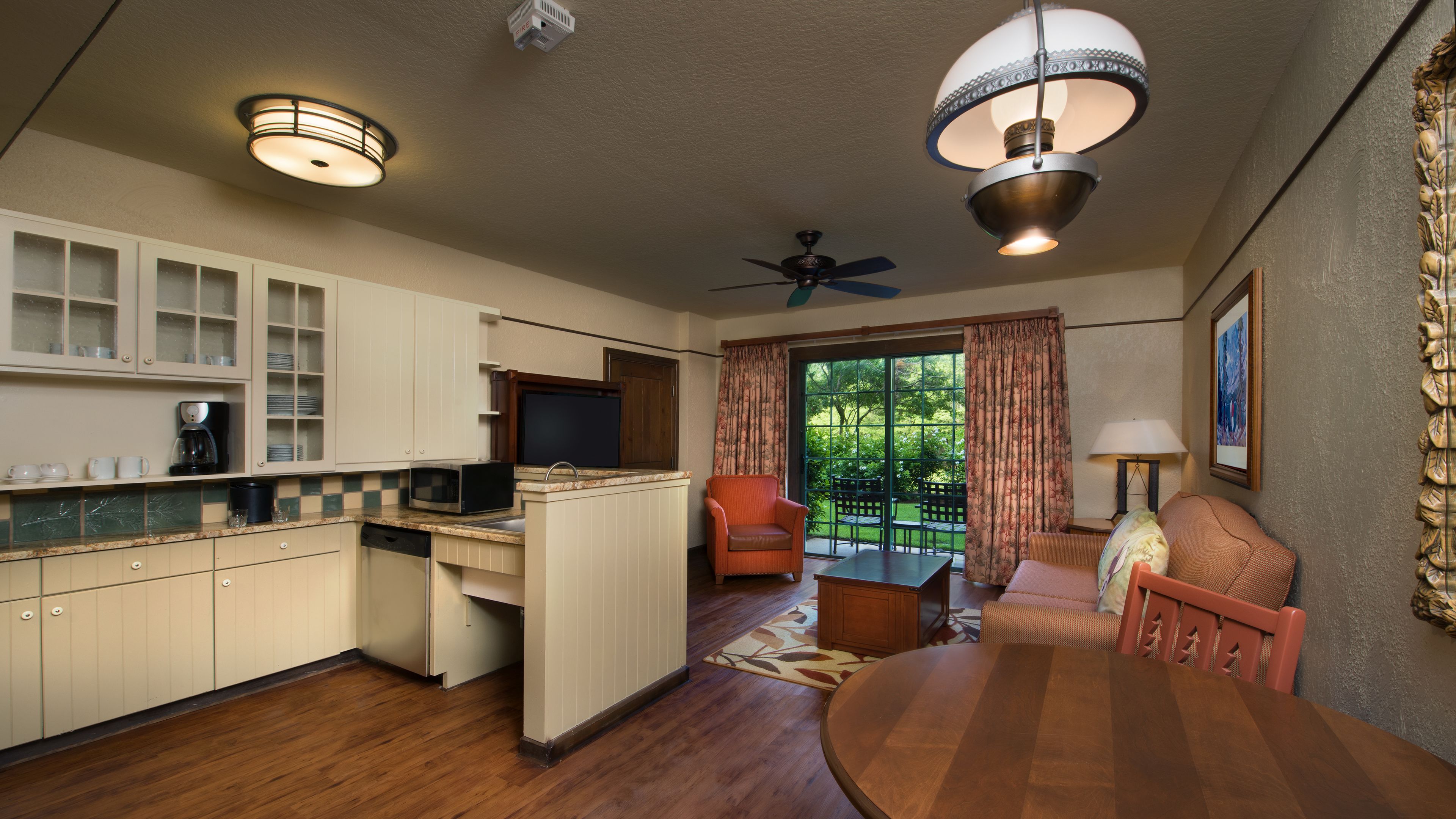 Una cocina compacta con comedor, ventilador de techo y vistas al exterior.