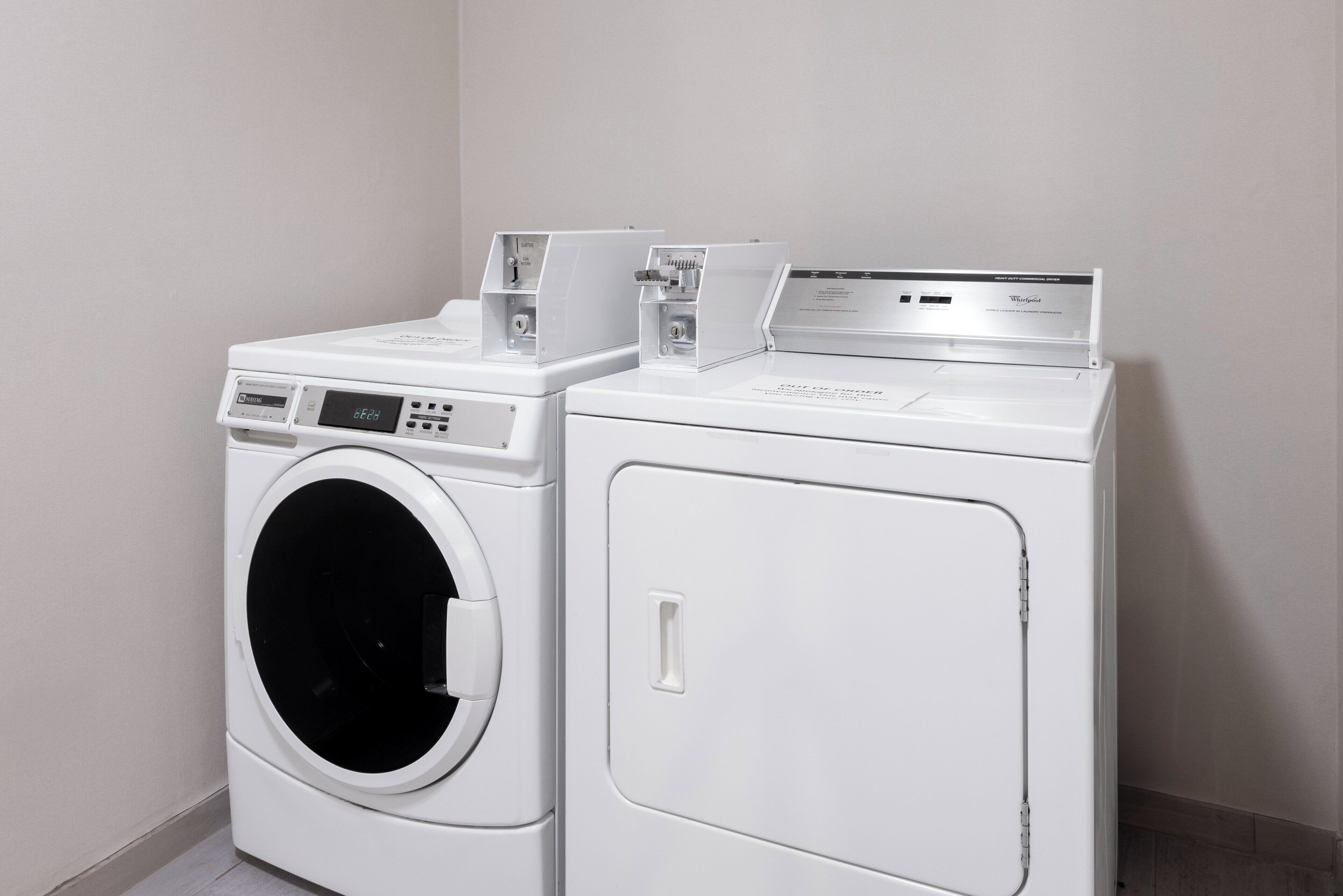 A laundry room with two stacked washing machines and a dryer.