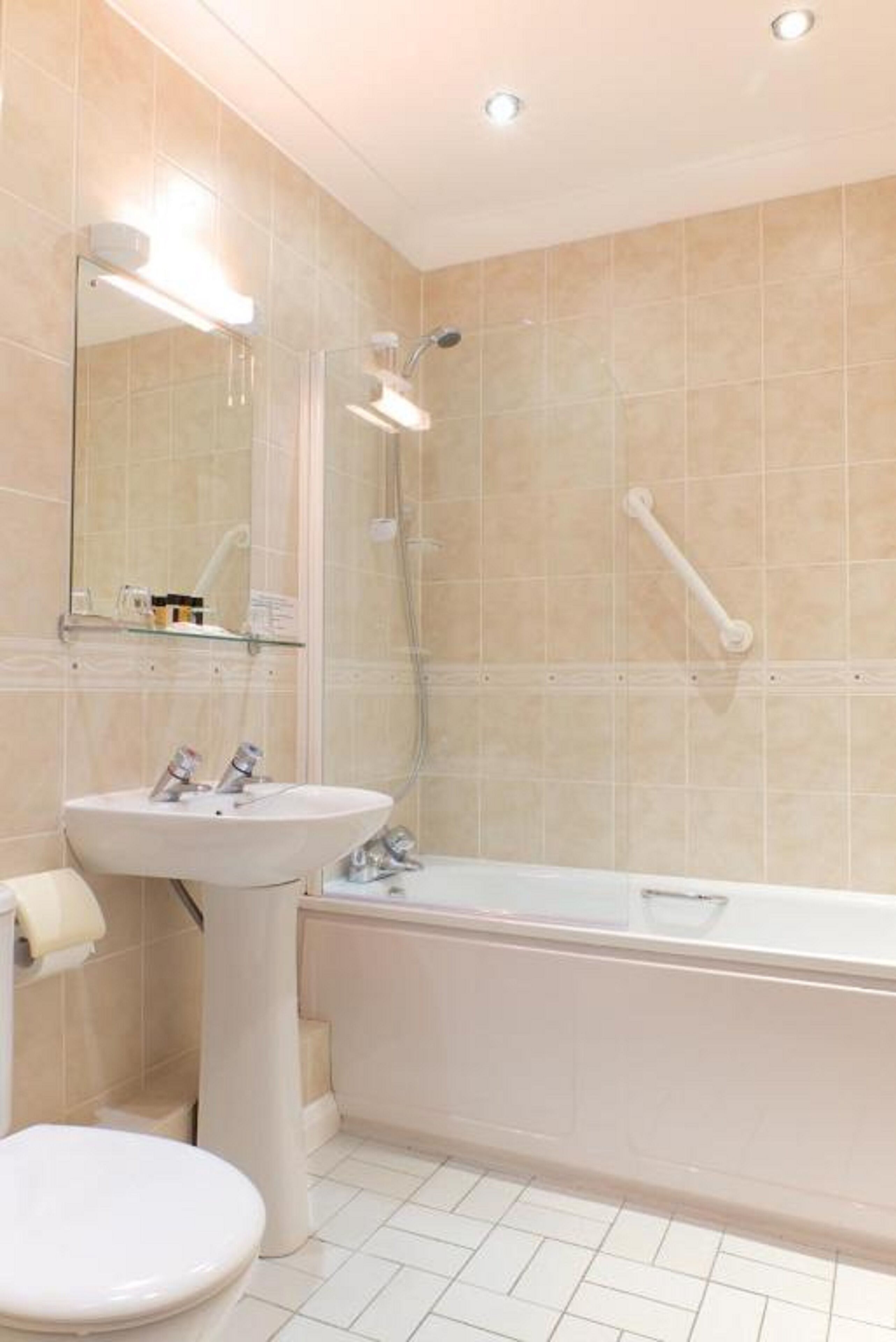 Un baño moderno con lavamanos, inodoro y bañera.