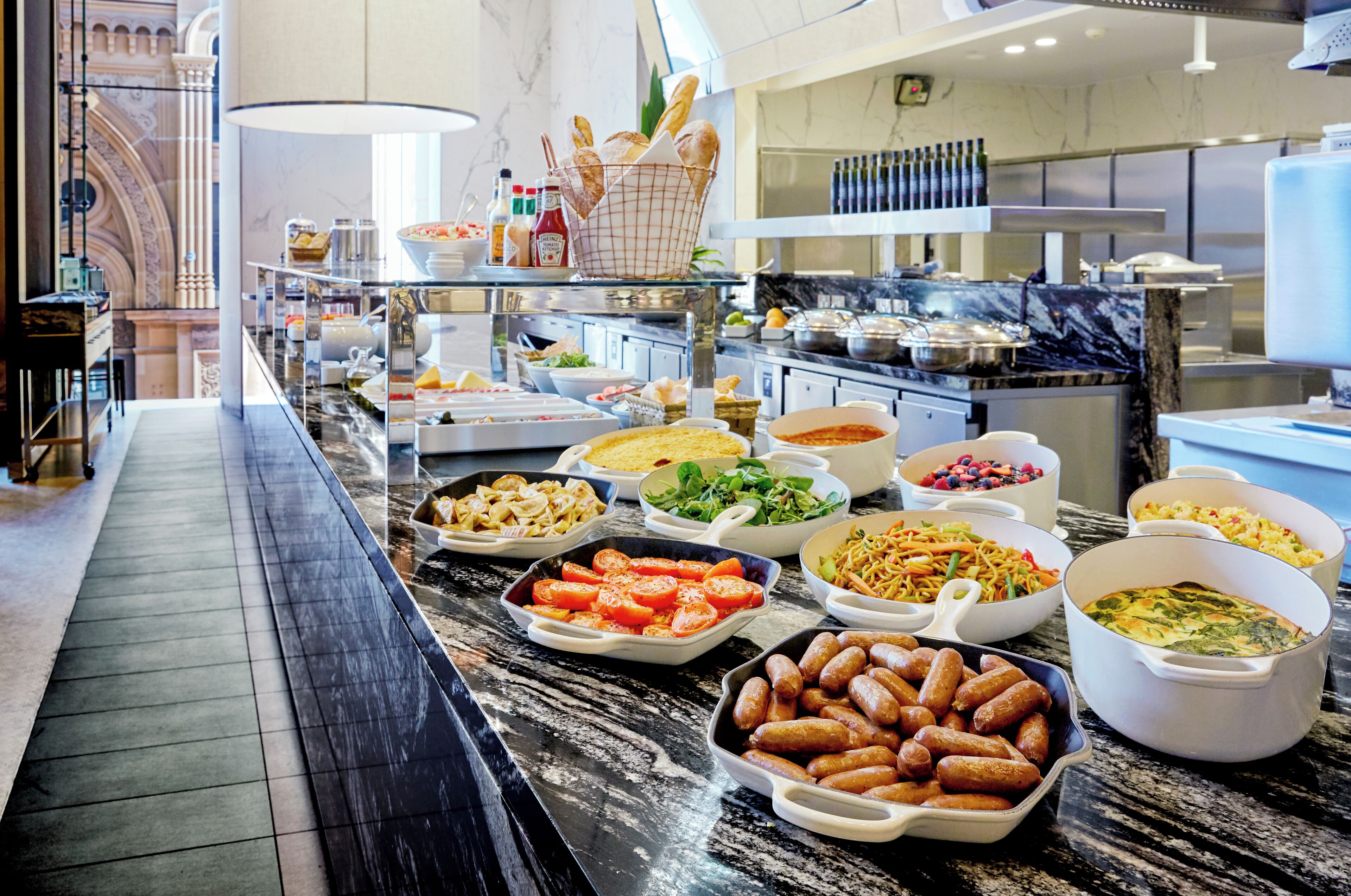 A buffet with various dishes and a marble countertop.