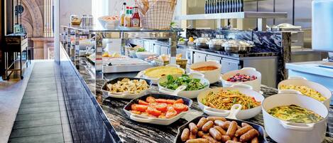 A buffet with various dishes and a marble countertop.