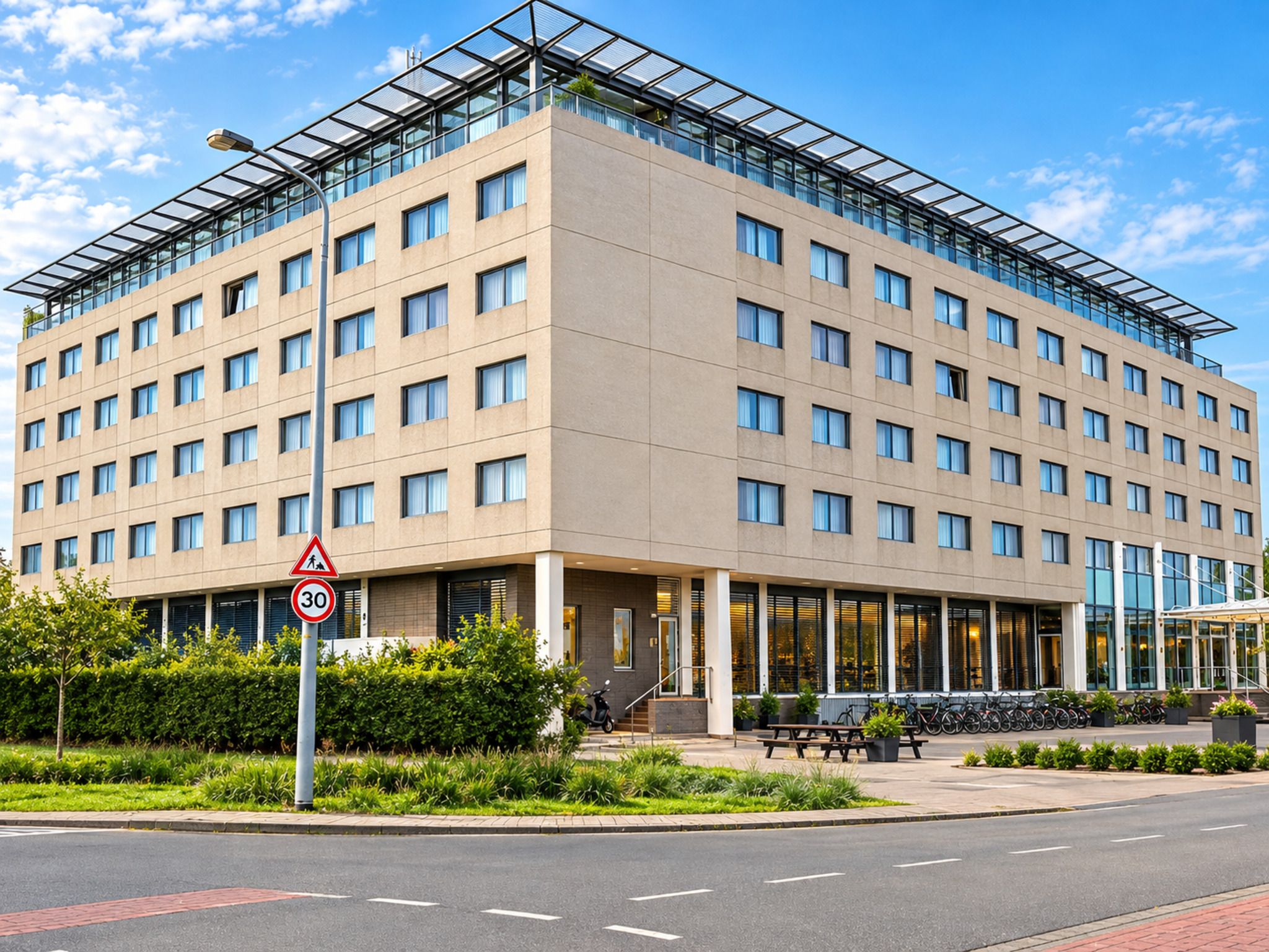 A modern multi-story hotel with a flat facade, large windows, and a covered entrance area.